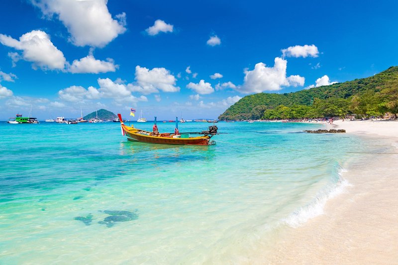 Aerial view of a serene island surrounded by blue ocean waters, offering a tropical getaway.