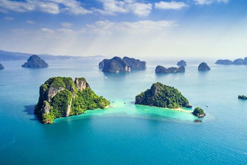 Tourists kayaking in the crystal-clear waters near Hong Island, surrounded by towering limestone cli